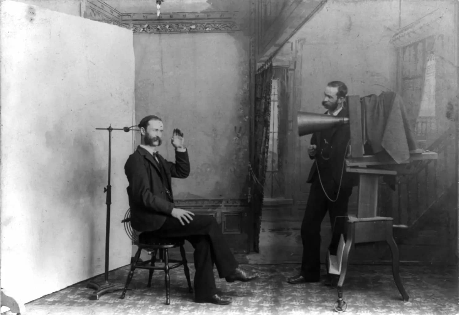 A nineteenth-century photographer and group posed inside a working studio