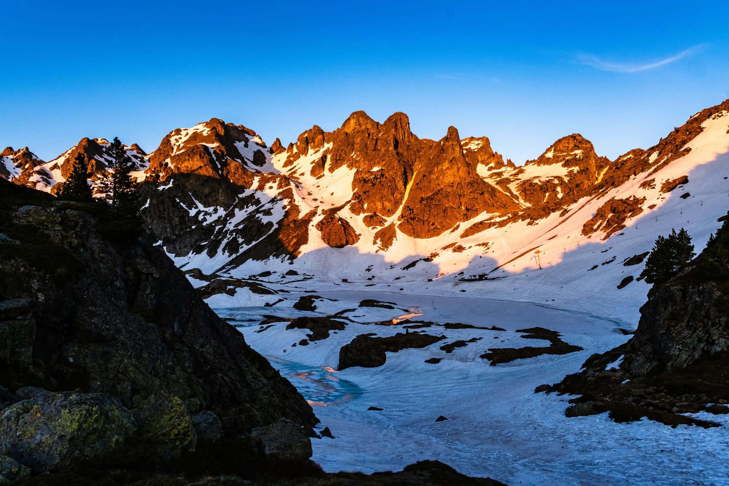 Snow-covered mountain peaks glowing orange in the final sunlight
