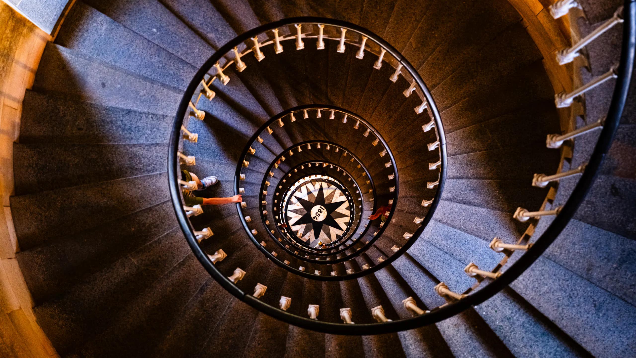 A spiral staircase seen from above, circling toward a patterned center